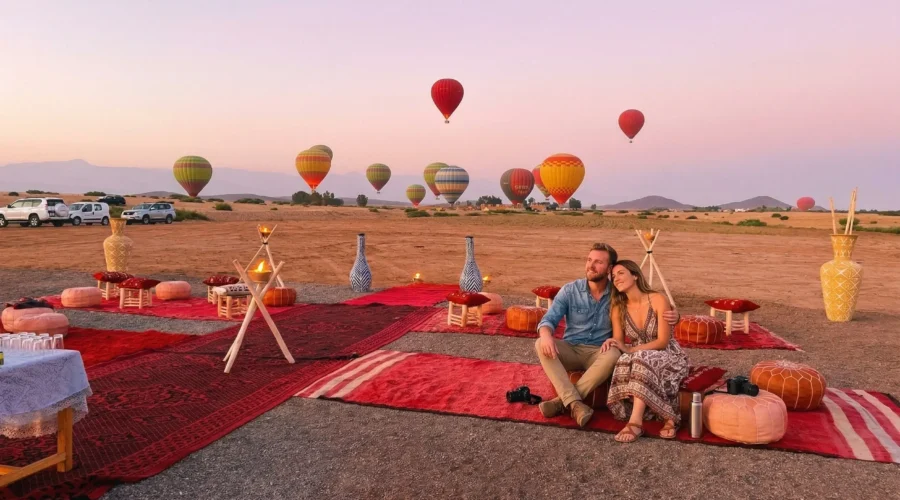 marrakech-hot-air-balloon-sunset-couple-desert-experience Couple enjoying sunset hot air balloon experience in Marrakech desert with multiple balloons in the sky