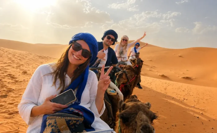 Travelers enjoying camel trekking in the Erg Chebbi dunes during a 6 days Marrakech to Merzouga desert tour
