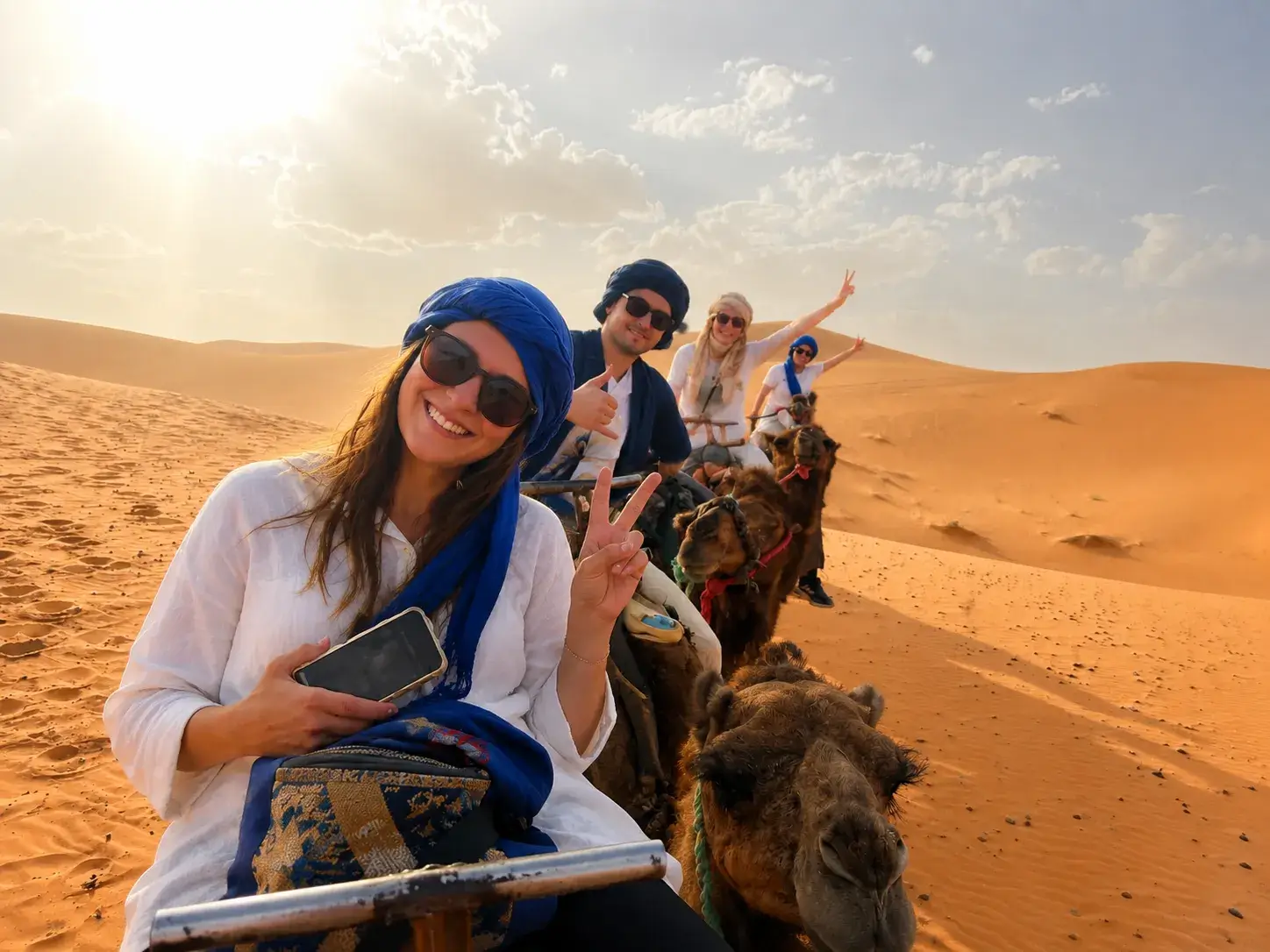 Travelers enjoying camel trekking in the Erg Chebbi dunes during a 6 days Marrakech to Merzouga desert tour