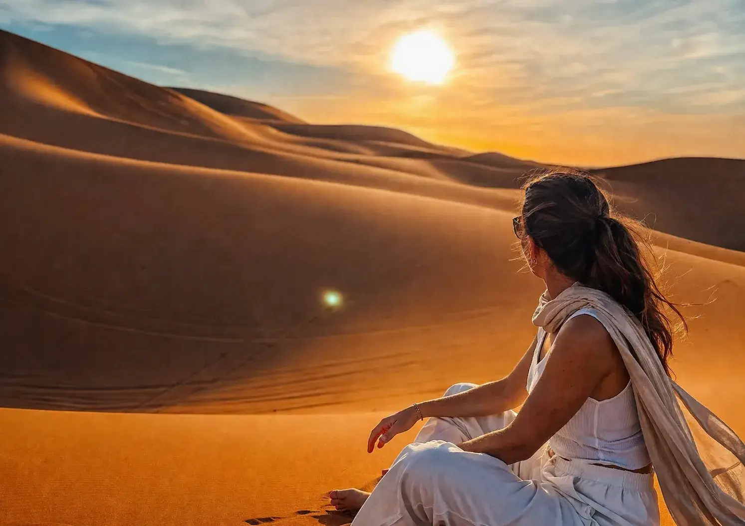 Woman watching sunset in Merzouga Sahara during the 2 days desert tour from Fes to Marrakech