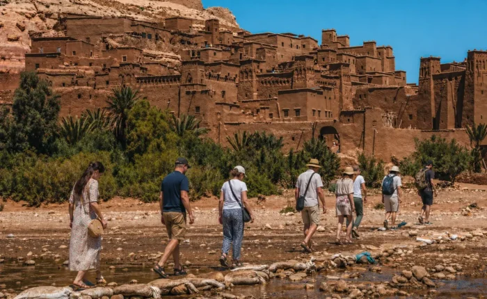 Travelers walking near Ait Ben Haddou on the 4 Days Fes to Marrakech Desert Tour