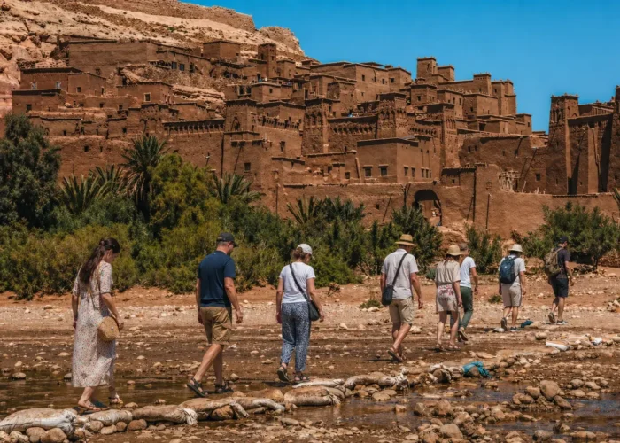 Travelers walking near Ait Ben Haddou on the 4 Days Fes to Marrakech Desert Tour
