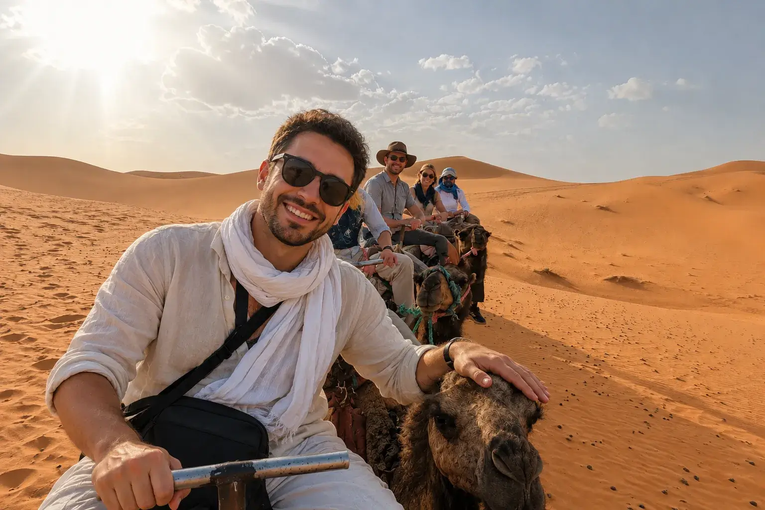 Tourists riding camels in the Merzouga Sahara during the 3 Days Fes to Marrakech Desert Tour