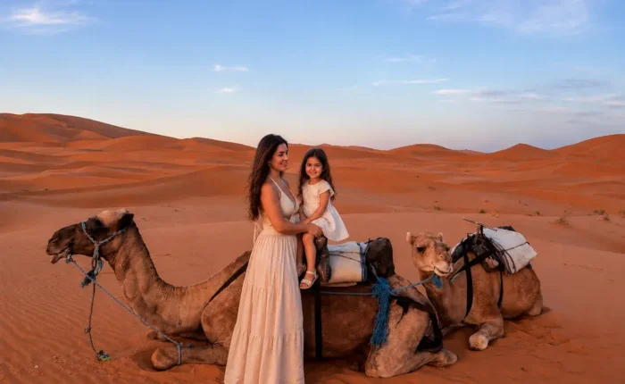 Mother and daughter with camel in Merzouga during the 4 Days Fes to Merzouga Desert Tour