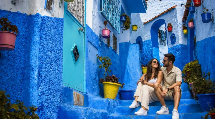 Couple exploring the blue streets of Chefchaouen during an 8 days Morocco tour from Fes