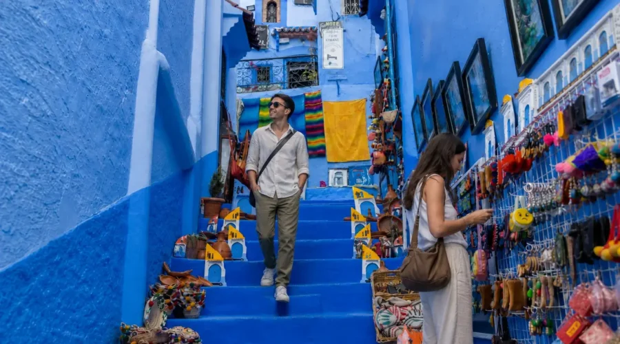 Travelers exploring the blue streets of Chefchaouen during a Morocco tour from Fes