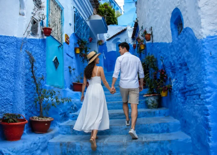Chefchaouen Day Trip from Fes, Couple walking through the blue streets of Chefchaouen during a day trip from Fes Morocco