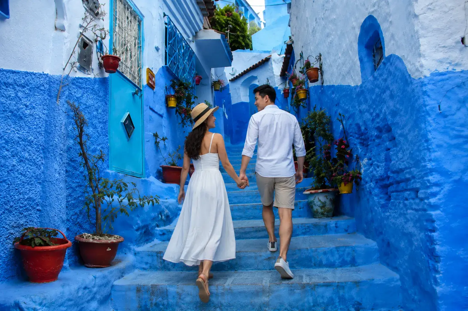 Chefchaouen Day Trip from Fes, Couple walking through the blue streets of Chefchaouen during a day trip from Fes Morocco